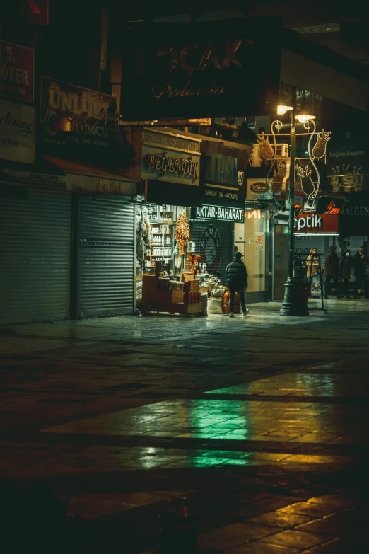 a man walking down a wet street at night, inspired by Elsa Bleda, unsplash contest winner, quirky shops, fallout style istanbul, old shops, deserted