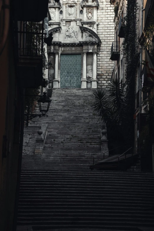 a stairway leading up to a building with a clock tower in the background, by Alessandro Allori, dark street, gif, terraced, low quality photo