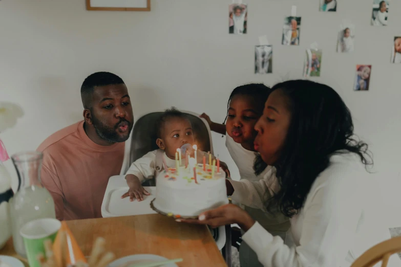 a family blowing out candles on a birthday cake, pexels contest winner, dark-skinned, parental advisory, thumbnail, 2 years old