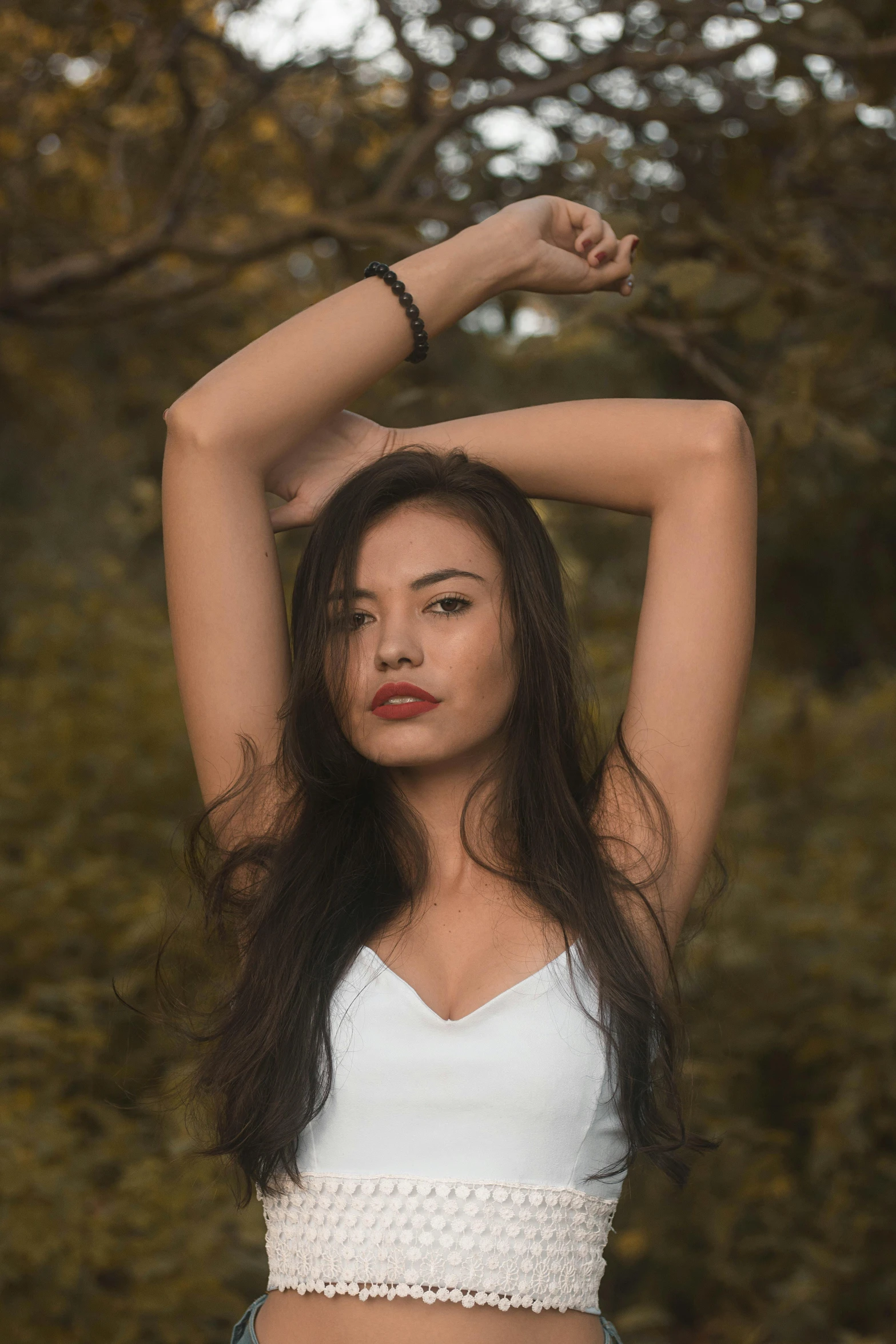 a woman posing for a picture in the woods, inspired by Elsa Bleda, pexels contest winner, renaissance, dark brown hair and tan skin, armpit, asian face, dressed in a white t-shirt