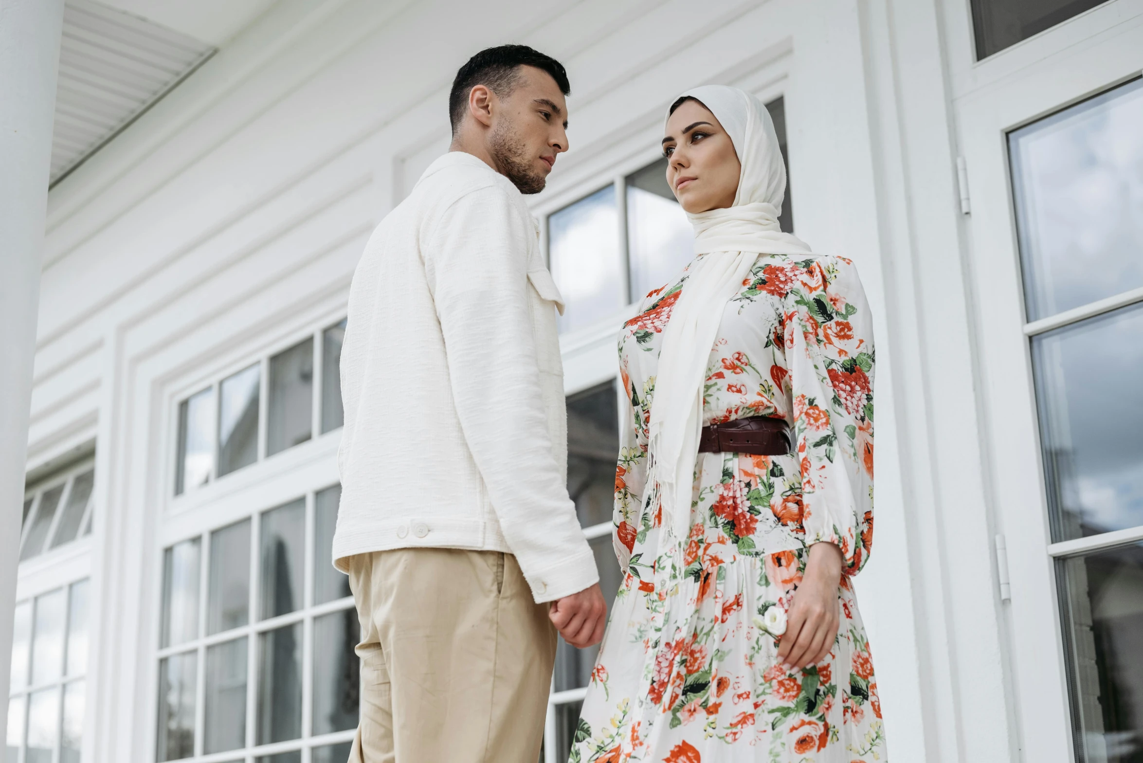 a man and a woman standing next to each other, trending on pexels, hurufiyya, floral clothes, modest, commercial, romantic lead