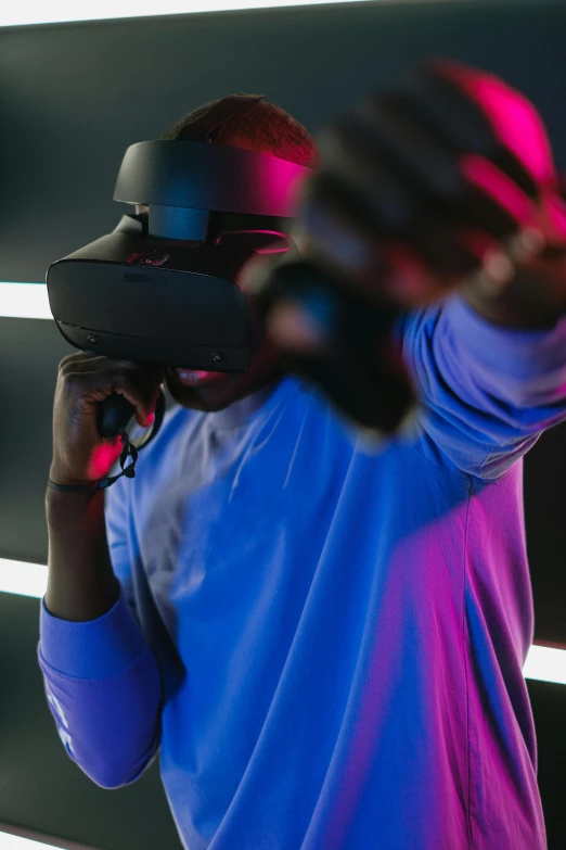 a man in a blue shirt using a virtual reality device, pexels contest winner, afrofuturism, rednered with raytracing, dark visor covering face, ceo of microsoft gaming ( xbox ), siggraph