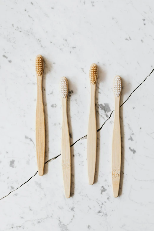 four bamboo toothbrushes lined up on a marble surface, by Nicolette Macnamara, unsplash, 1 6 x 1 6, ready to eat, nordic, jen atkin