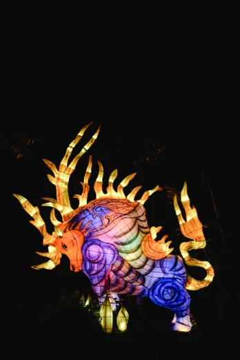 a colorful sculpture is lit up in the dark, inspired by Li Kan, pexels contest winner, yellow dragon head festival, back lit lighting, nautilus, taken in the late 2000s