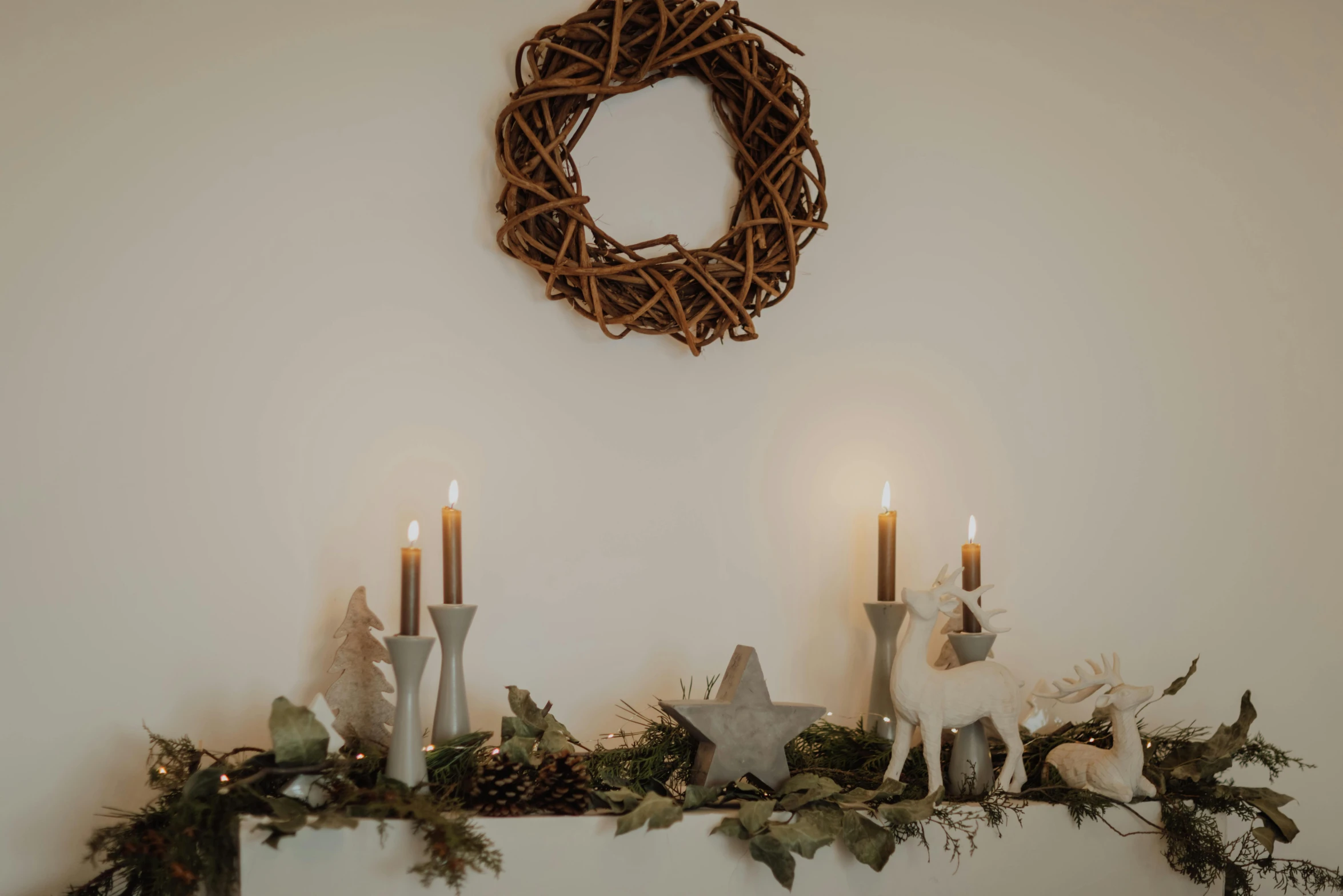 a couple of candles sitting on top of a mantle, inspired by Ernest William Christmas, unsplash, light grey backdrop, wreath of ferns, various lighting mood, modeled