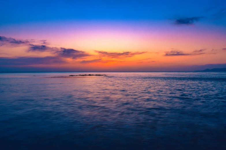 a large body of water with a sunset in the background, pexels contest winner, romanticism, blue and purple, cyprus, sleepy, photo of the middle of the ocean