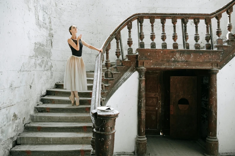 a woman standing at the top of a set of stairs, by Lucia Peka, pexels contest winner, arabesque, playbill of prima ballerina, dressed in a worn, photo for a magazine, performing