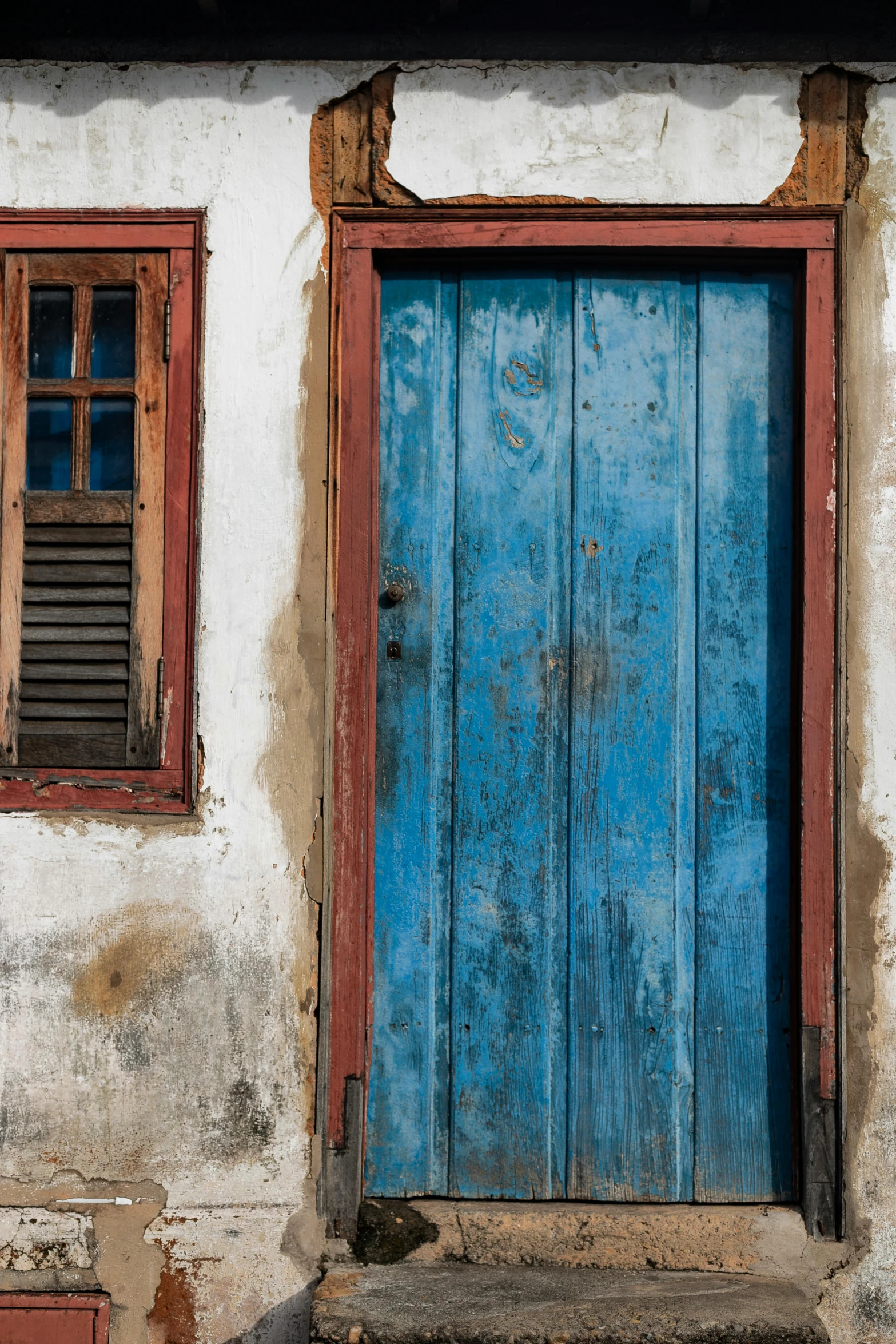 a blue door sitting on the side of a building, by Peter Churcher, brazil, rustic wood, brown red blue, coast