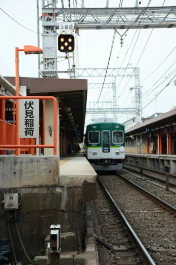 a train pulling into a train station next to a platform, by Sengai, green lines, けもの, square, raku