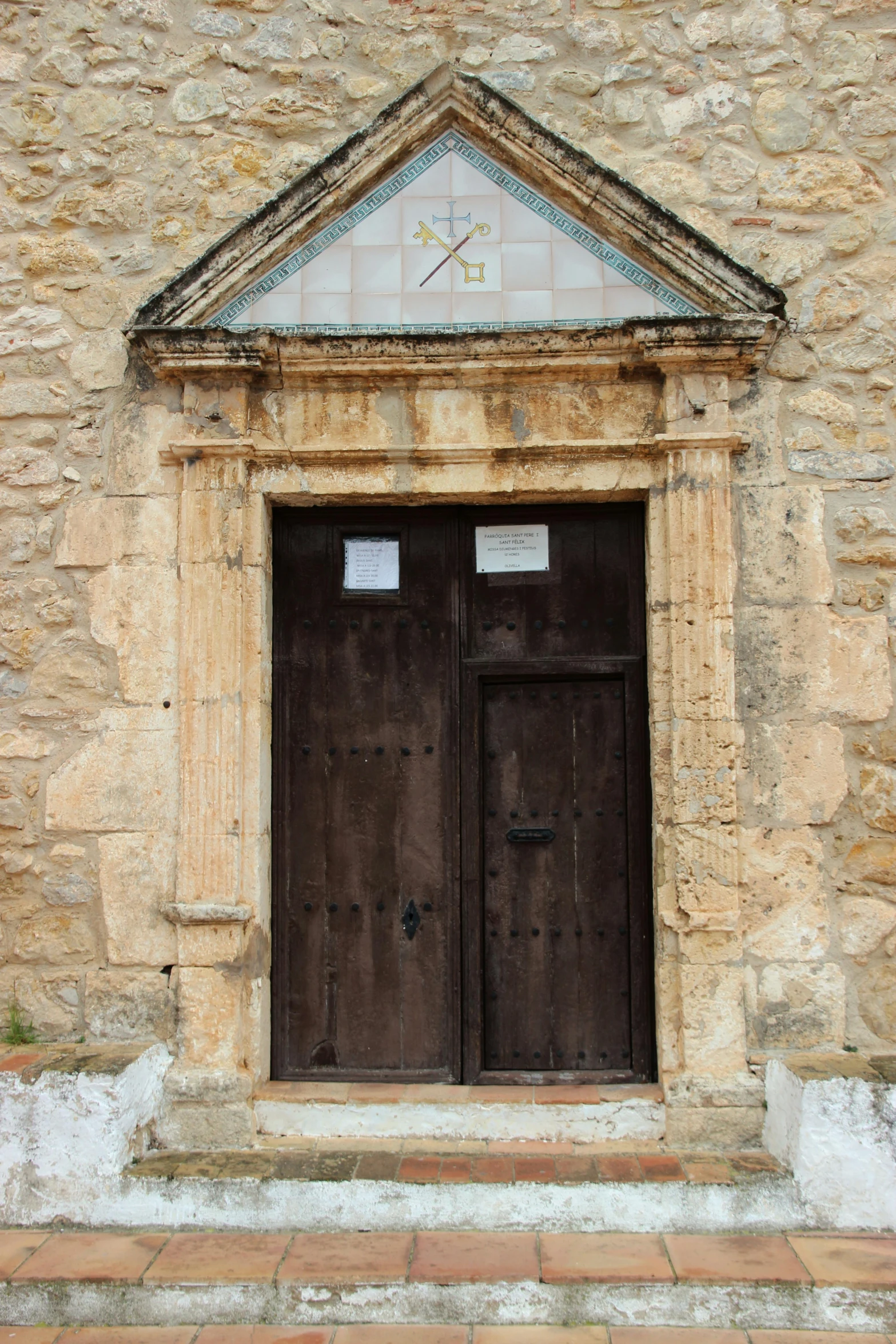 a black fire hydrant sitting in front of a stone building, an album cover, by Carlo Carrà, romanesque, wood door, cyprus, orthodox saint, perhaps