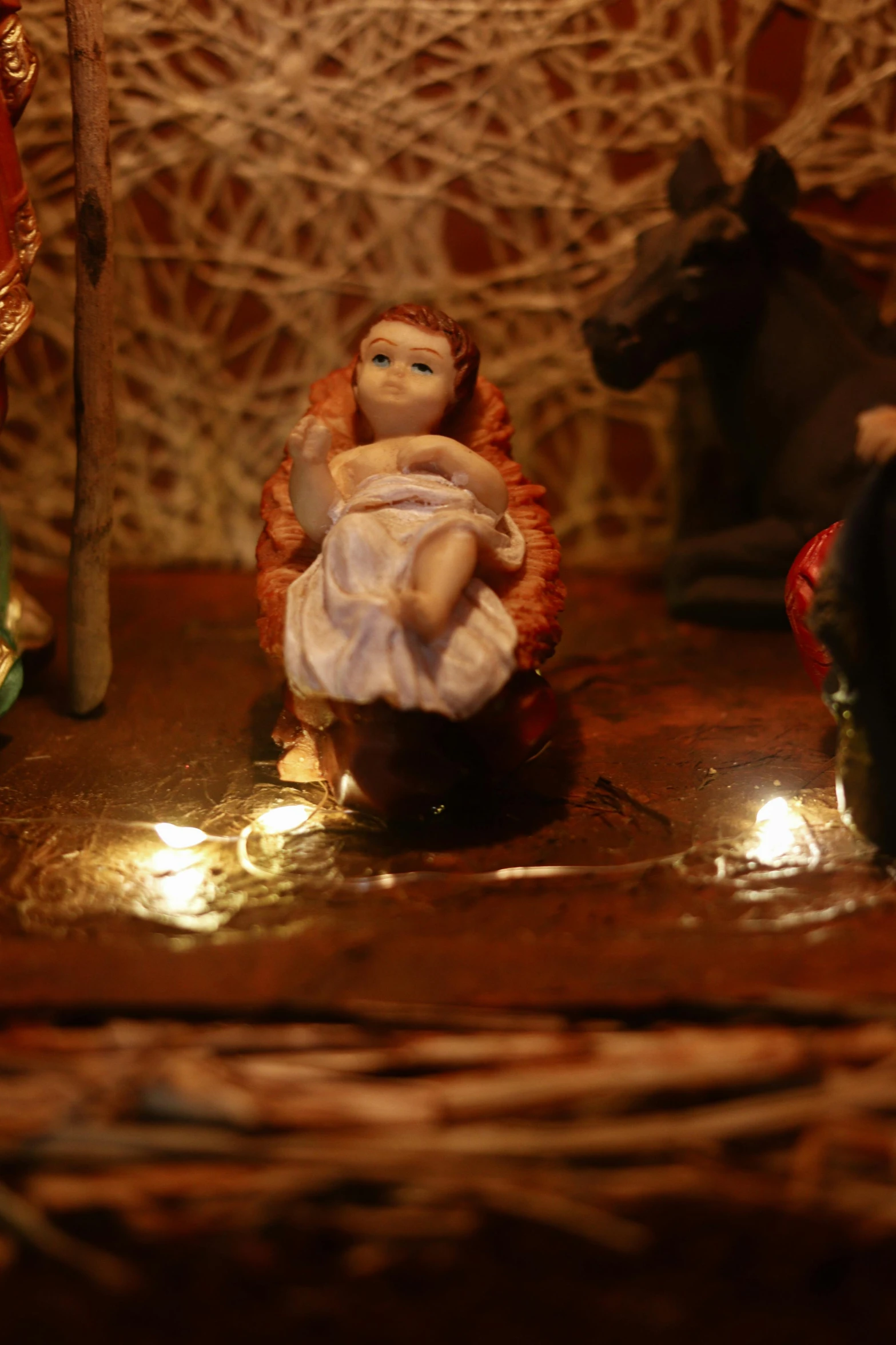 a couple of figurines sitting on top of a table, with infant jesus, lights, detail, slide show