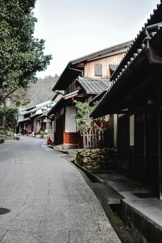 a person riding a bike down a street, inspired by Maruyama Ōkyo, trending on unsplash, mingei, old village, exterior view, deserted, ethnicity : japanese