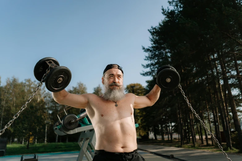 a man with a beard is lifting two dumbbells, a portrait, by Julia Pishtar, pexels contest winner, long white beard, formless brests, high quality photo, tourist photo