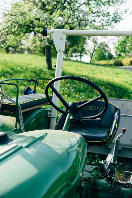 a green tractor sitting on top of a lush green field, inside of a car, chairlifts, helmet view, lawns