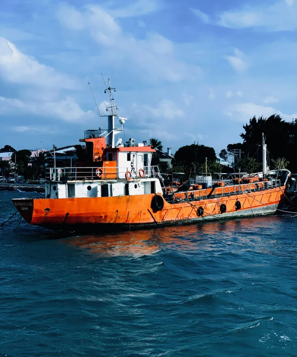 a large orange boat floating on top of a body of water, on the sea, harbour, thumbnail, malaysian