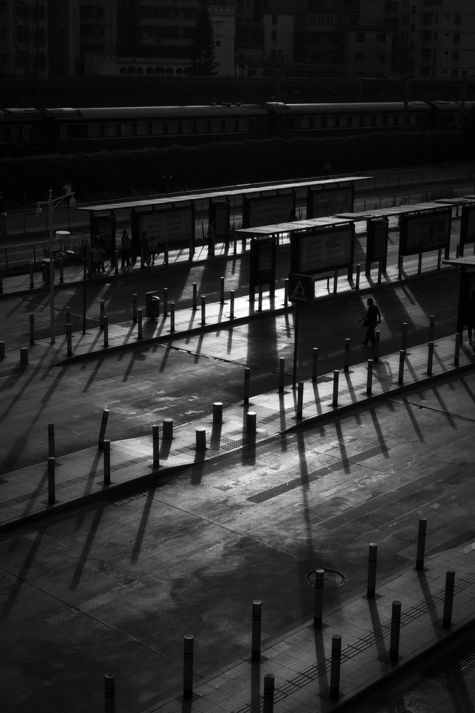 a black and white photo of a train station, inspired by Pierre Pellegrini, postminimalism, some stalls, evening sunlight, docks, square