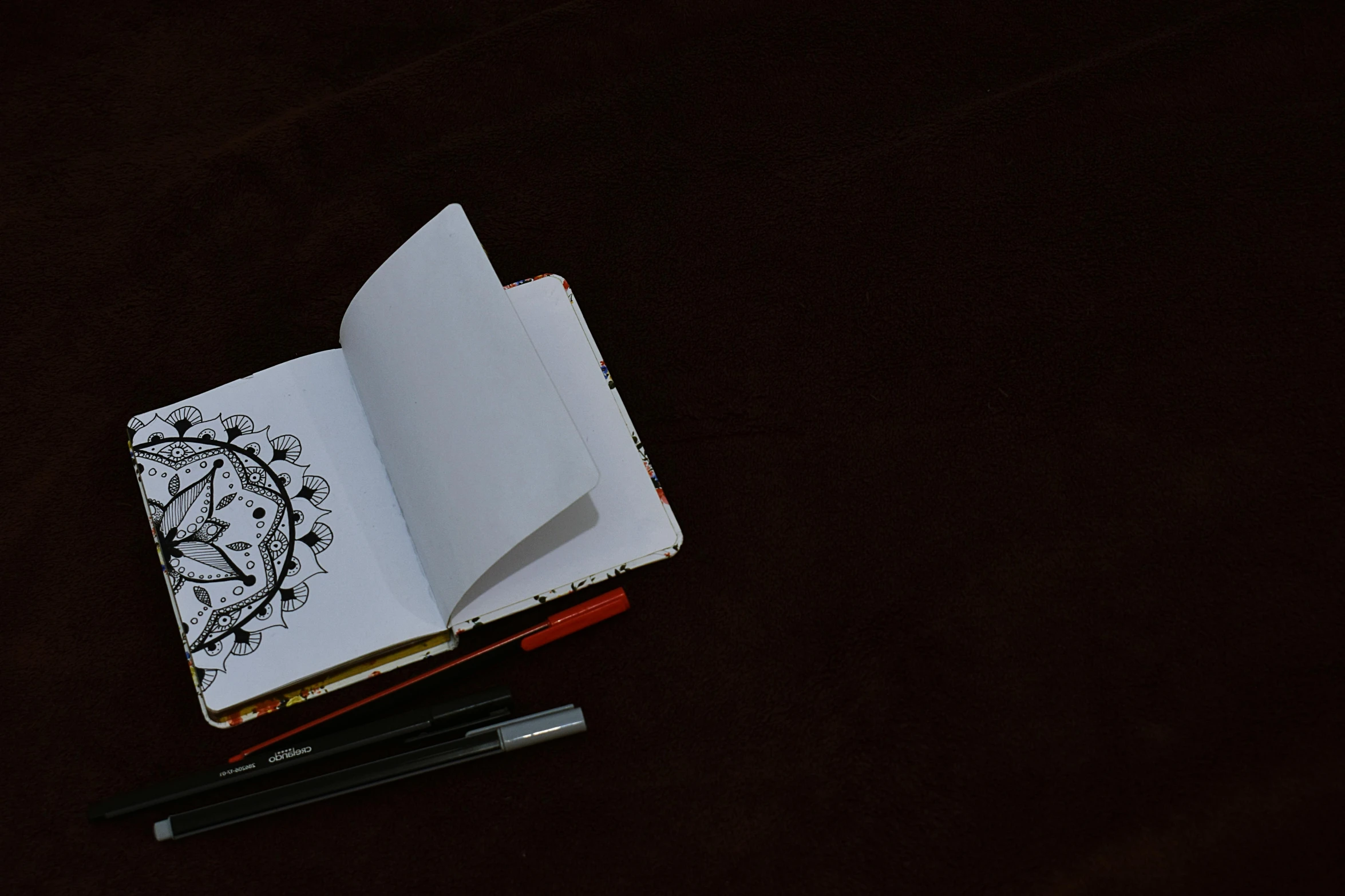 an open book sitting on top of a table next to a pen, a drawing, pexels contest winner, sots art, mandalas, album cover, full page black, portait image