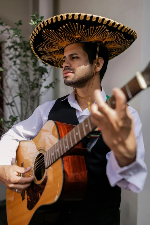 a man in a sombren playing a guitar, an album cover, inspired by Germán Londoño, pexels contest winner, traditional dress, squinting at high noon, 🚿🗝📝