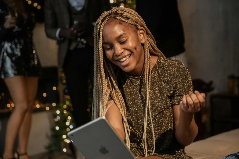 a woman sitting on a bed using a laptop, a portrait, by Chinwe Chukwuogo-Roy, pexels contest winner, happening, smiling and dancing, wearing festive clothing, took on ipad, bringing people together