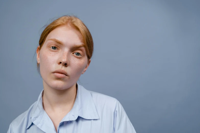 a close up of a person wearing a shirt, a character portrait, trending on pexels, a redheaded young woman, light blue skin, timid and vulnerable expression, skin blemishes