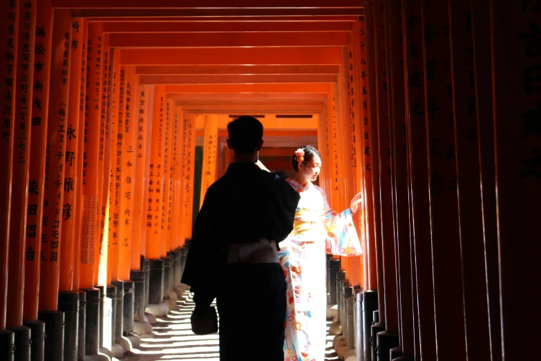 a bride and groom standing in a tunnel of tori tori tori tori tori tori tori tori tori, inspired by Torii Kiyomoto, pexels contest winner, black and orange, inside her temple, taken in the late 2010s, rectangle