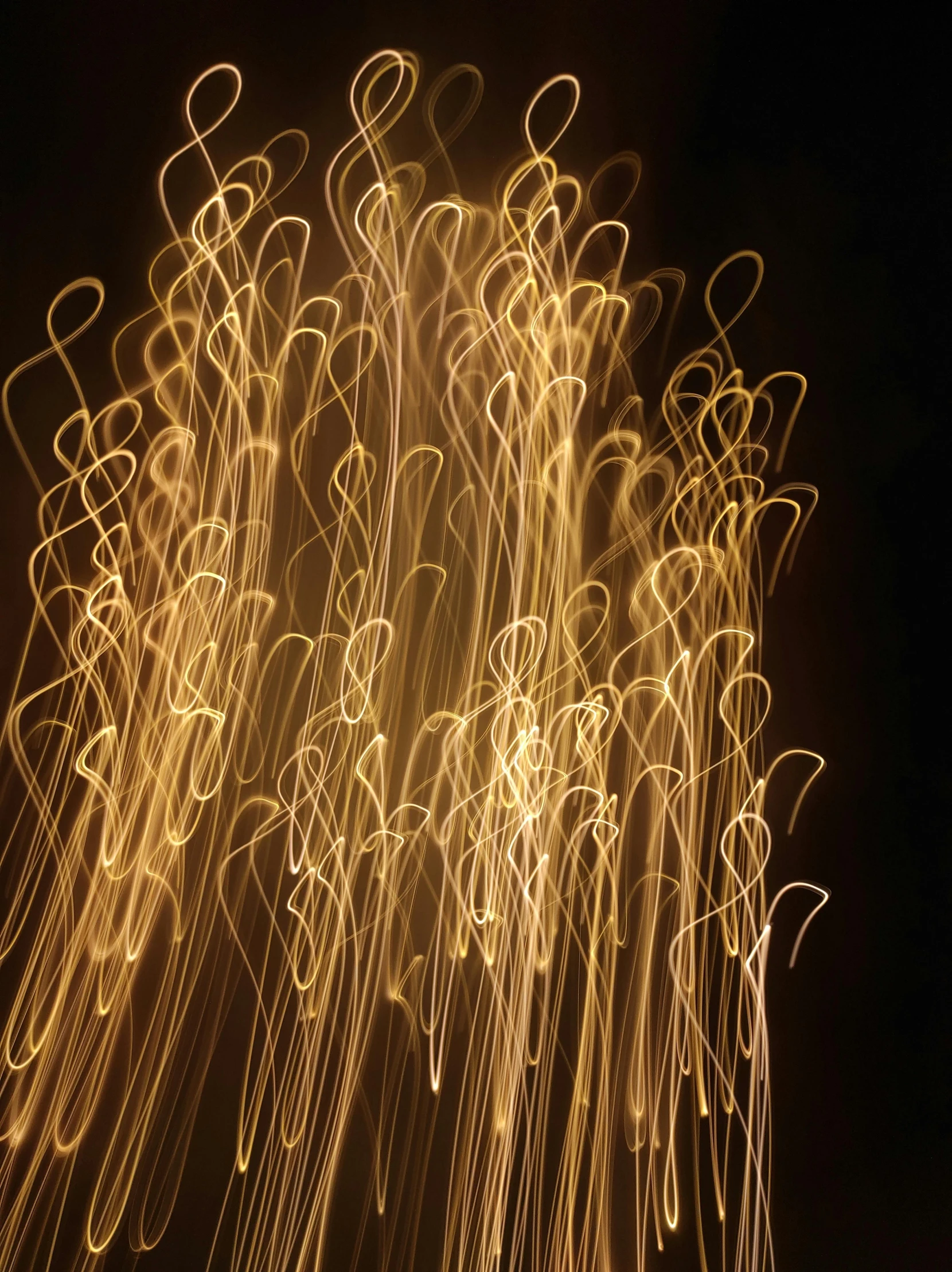 a close up of a firework on a black background, inspired by Bruce Munro, lyrical abstraction, golden curve composition, taken on iphone 14 pro, electricity archs, portrait photo