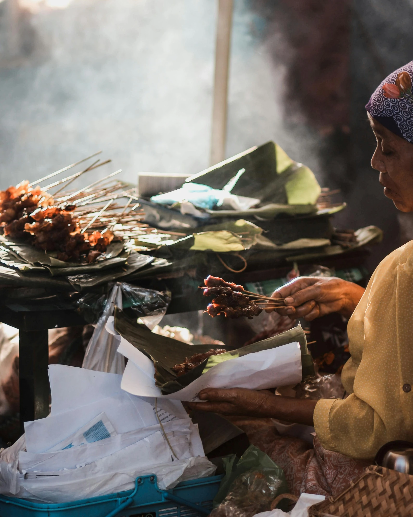 a woman sitting in front of a table filled with food, by Sam Dillemans, pexels contest winner, sumatraism, praying with tobacco, skewer, thumbnail, square