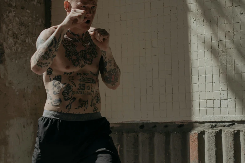 a man with tattoos is brushing his teeth, inspired by Seb McKinnon, pexels contest winner, boxing stance, action scene screenshot, action with run and fight, wearing shipibo tattoos