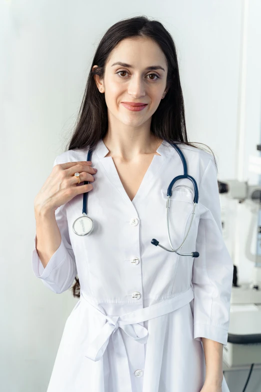 a woman in a white lab coat holding a stethoscope, tech robes, upper body image, girl wearing uniform, trending photo