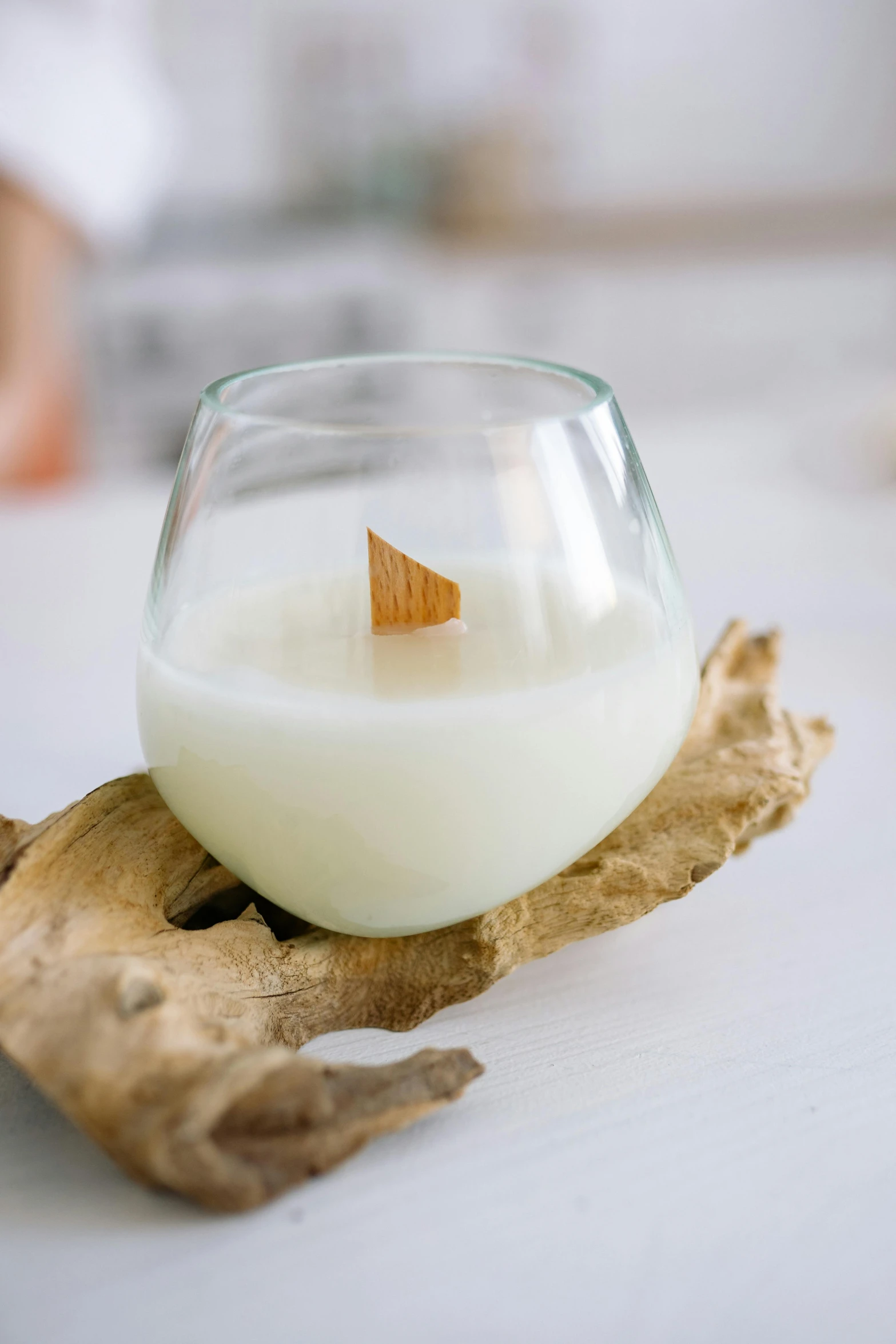 a glass of milk sitting on top of a piece of wood, shaped like a yacht, waxy candles, organic detail, detailed product image