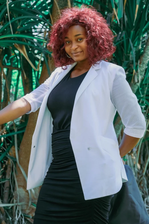 a woman in a black dress and a white jacket, lab coat and tee shirt, mongezi ncaphayi, with curly red hair, with a tree in the background