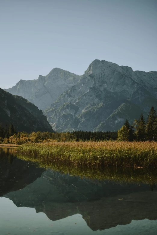 a body of water with mountains in the background, munich, fan favorite, cinematic lut, f / 2 0