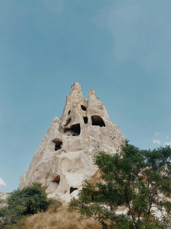 a group of people standing on top of a hill, inspired by Dalí, trending on pexels, empty bathhouse hidden in a cave, tall stone spires, middle close up, hill with trees