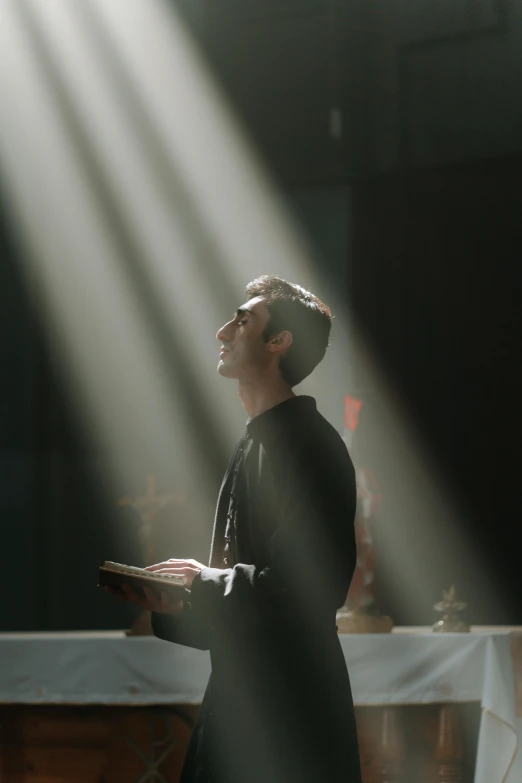 a man that is standing in front of a table, holy rays, scene from church, cinematic lighting + masterpiece, biblically accurate