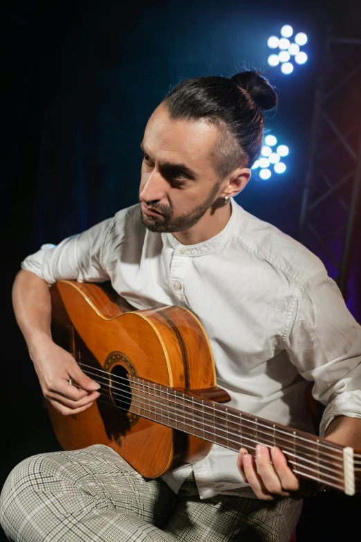 a man in a white shirt is playing a guitar, inspired by david rubín, antipodeans, looking off to the side, artem, backdrop, saadane afif