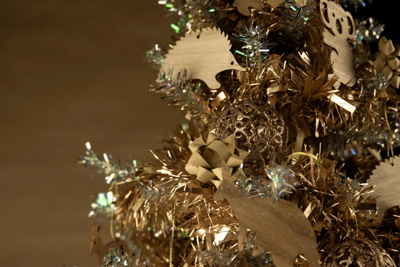 a close up of a christmas tree with decorations, inspired by Ernest William Christmas, baroque, realistic metal reflections, cardboard, gold dappled lighting, rendered in cinema 4 d