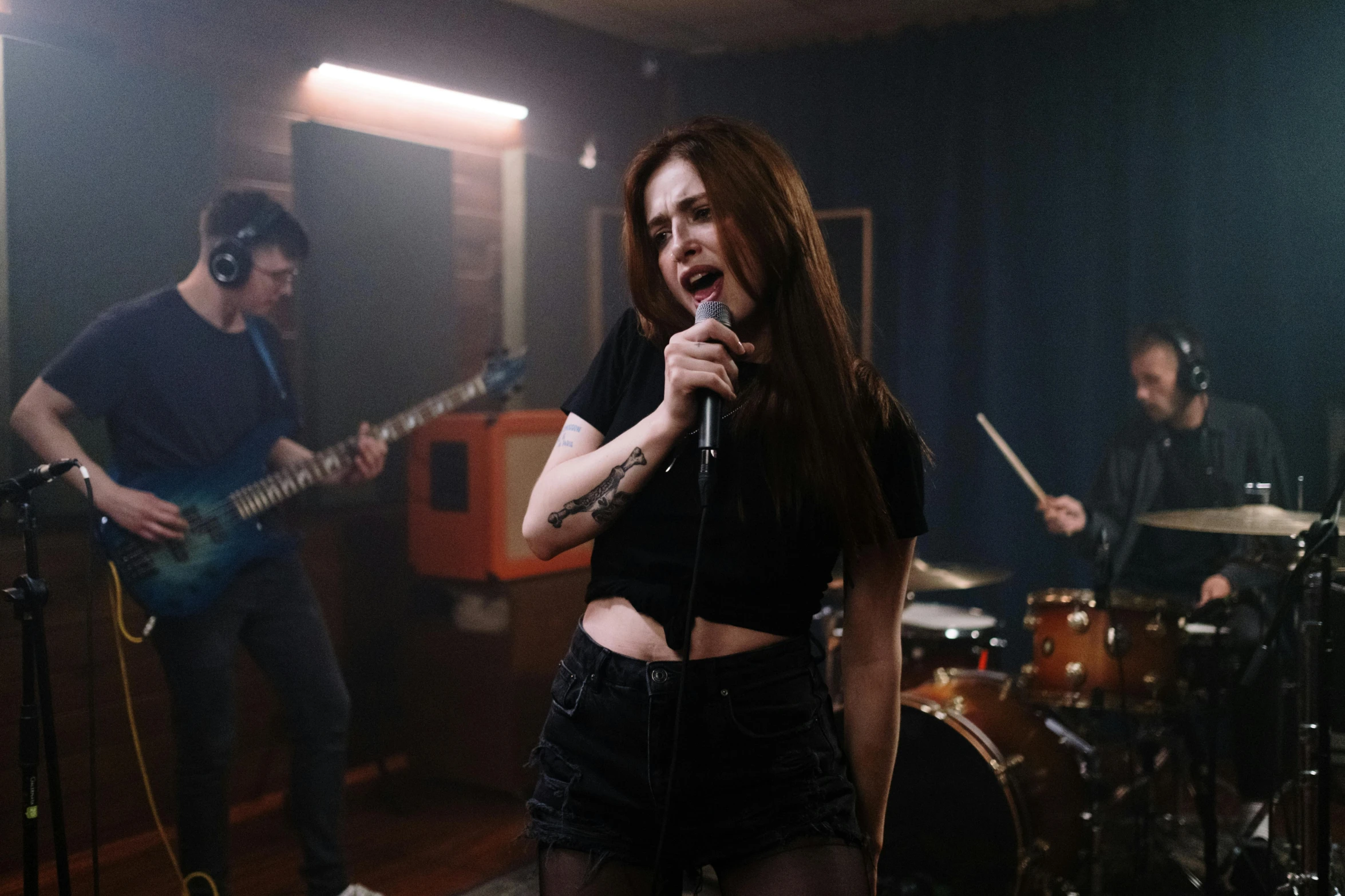 a woman singing into a microphone in a music studio, an album cover, inspired by Elsa Bleda, pexels contest winner, antipodeans, teenage grunge punk rock, performing a music video, katherine mcnamara inspired, playing drums