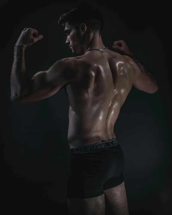 a man flexing his muscles in the dark, by Cosmo Alexander, pexels contest winner, renaissance, arched back, non binary model, profile image, dripping skin