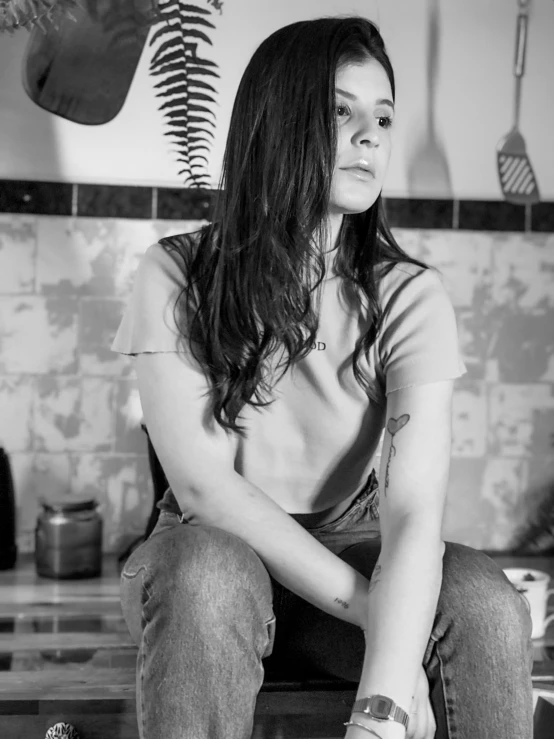 a black and white photo of a woman sitting on a counter, a black and white photo, by Lucia Peka, ellie bamber, young southern woman, grungy woman, josh grover