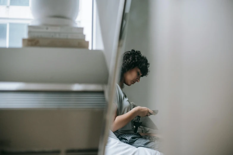 a young boy sitting on a bed reading a book, pexels contest winner, hyperrealism, goddess checking her phone, coming down the stairs, curly haired, people at work