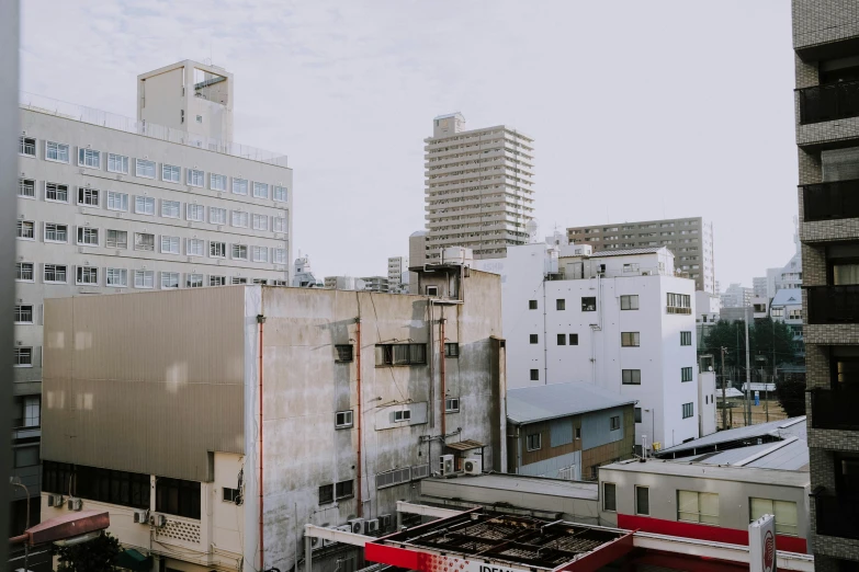 a view of a city from a high rise building, a photo, by Eizan Kikukawa, unsplash, brutalism, white wall complex, 2 0 0 0's photo