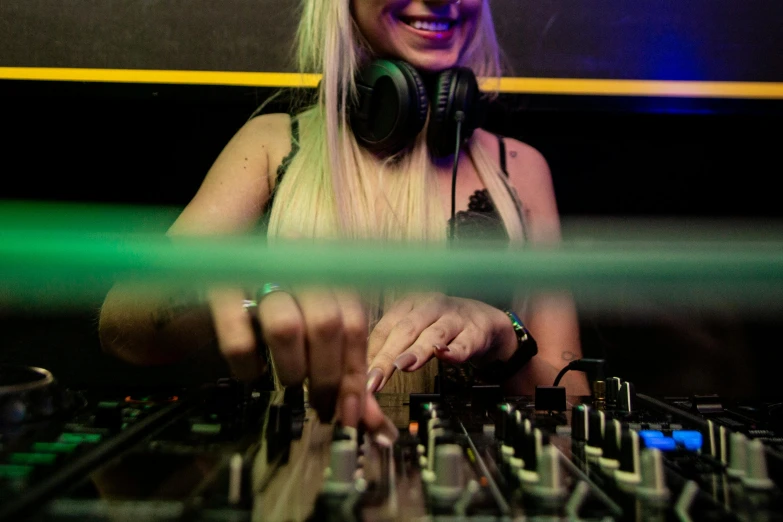 a woman that is standing in front of a mixer, an album cover, pexels, nightclub, avatar image, blonde, performing