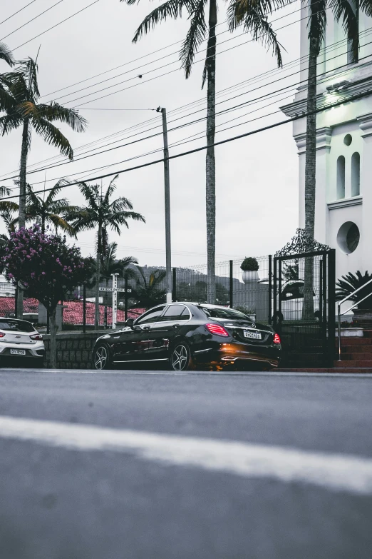 a couple of cars parked on the side of a road, by Niko Henrichon, pexels contest winner, renaissance, in front of a temple, te pae, black car, mercedez benz