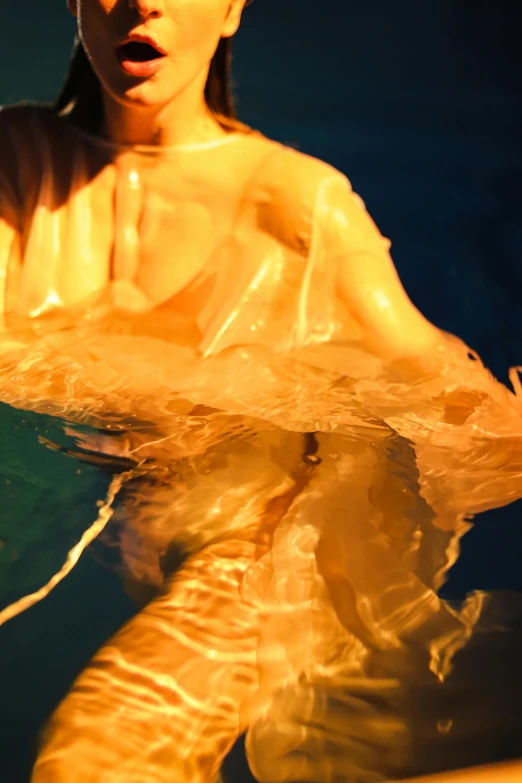 a woman that is in the water with a surfboard, inspired by Lynda Benglis, plasticien, glowing amber, close - up photograph, flowing silk sheets, jelly glow