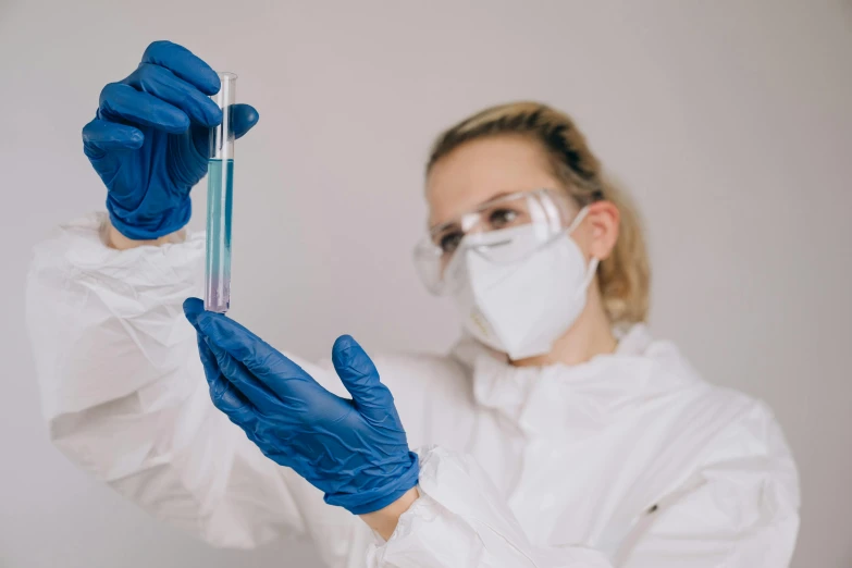 a woman in a lab coat holding a test tube, pexels contest winner, blue gloves, avatar image, neoprene, hazmat