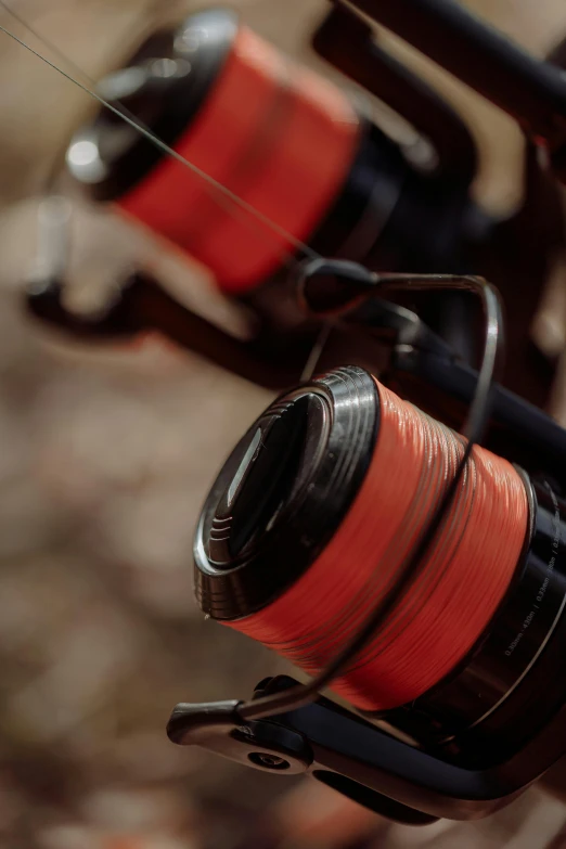 a close up of a fishing rod and reel, by Daniel Seghers, black and red scheme, hasselblad quality, [ cinematic, gaming