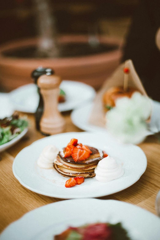 a wooden table topped with plates of food, by Adam Marczyński, unsplash, renaissance, living food adorable pancake, thumbnail, low quality photo, white