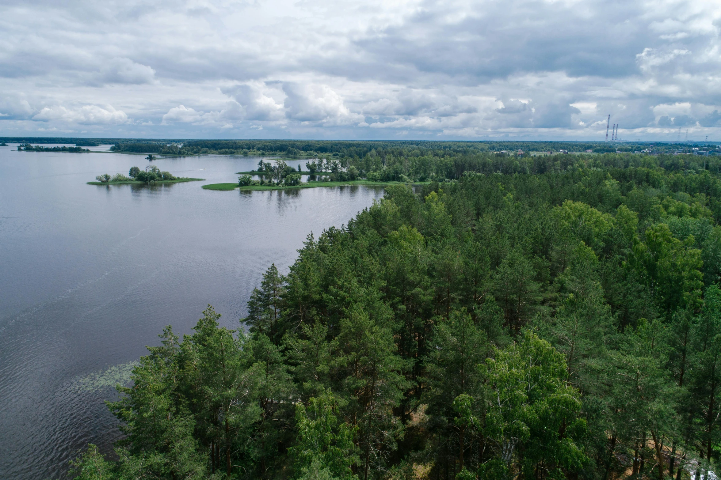 a large body of water surrounded by trees, by Grytė Pintukaitė, pexels contest winner, hurufiyya, wide river and lake, tarmo juhola, hd footage, grey