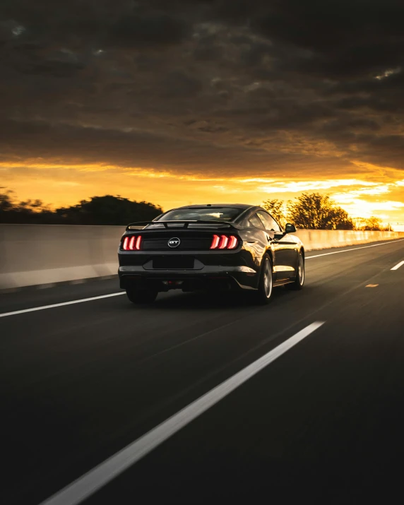 a mustang driving down a highway at sunset, by Josh Bayer, pexels contest winner, lgbtq, back arched, black car, profile image