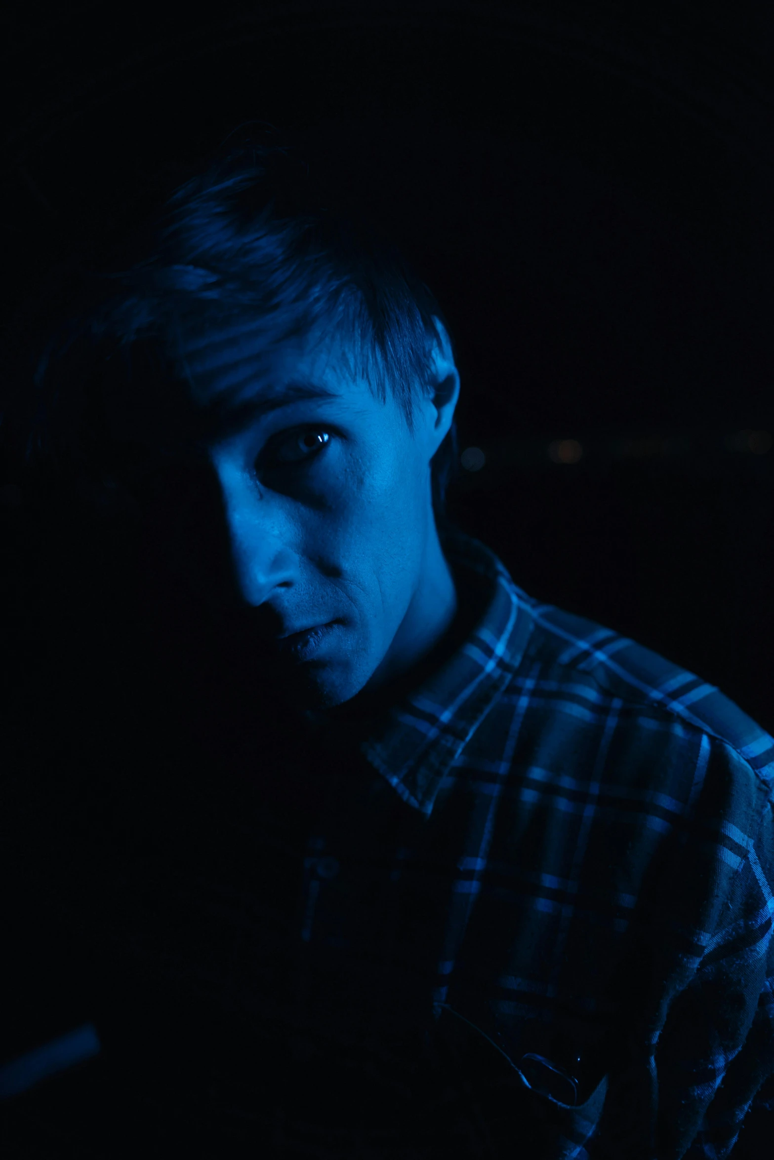 a close up of a person in a dark room, by Tobias Stimmer, mrbeast, joel fletcher, ((blue)), thin young male